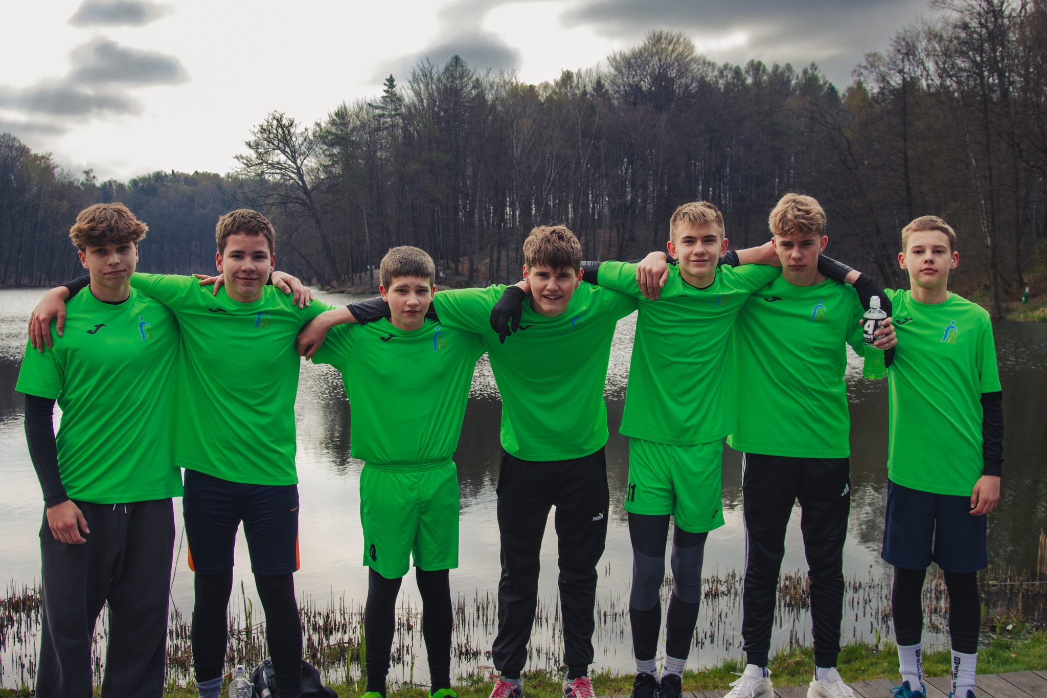 Chłopcy pozują do zdjęcia, ubrani w&nbsp;zielone, sportowe koszulki