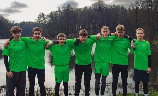 Chłopcy w sportowych strojach pozują do zdjęcia